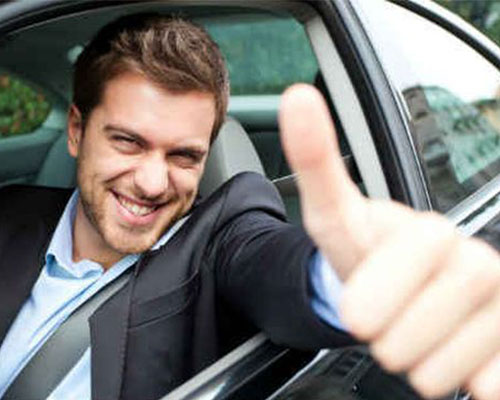 successful man driving car thumbs up